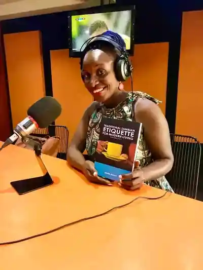 Marita Banda during a radio interview holding her book